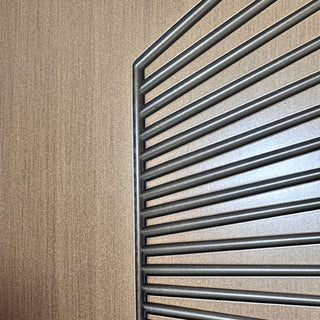 Close-up of FRAMEWELL antique brass fiberglass door, showcasing its brushed metallic finish & sunburst grooves.