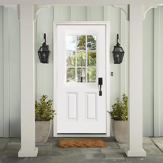 Primed white FRAMEWELL fiberglass entry door (36x80) with 9-lite clear glass, black hardware, and traditional raised panels, enhancing a bright, stylish entryway.